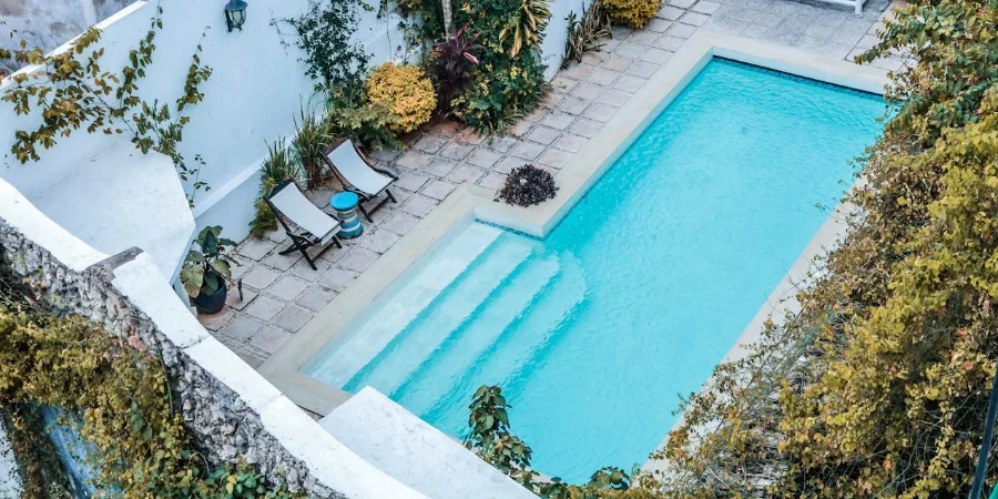 gunitado-para-piscinas-patio-interior Piscina construida con gunitado en un patio interior, rodeada de vegetación y acabados personalizados